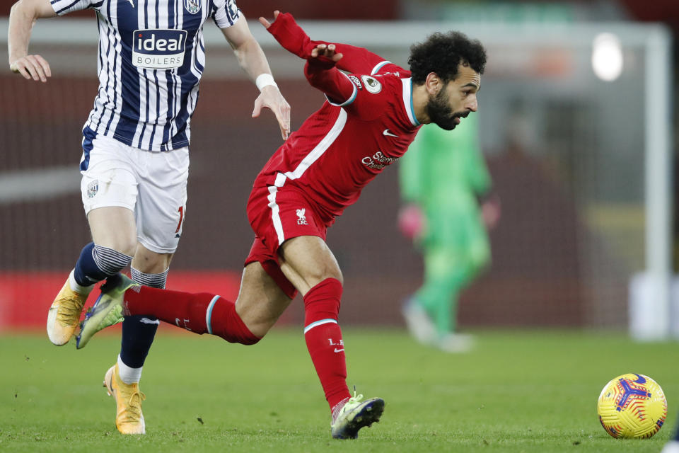 Liverpool's Mohamed Salah chases the ball during an English Premier League soccer match between Liverpool and West Bromwich Albion at the Anfield stadium in Liverpool, England, Sunday Dec. 27, 2020. (Clive Brunskill/Pool via AP)