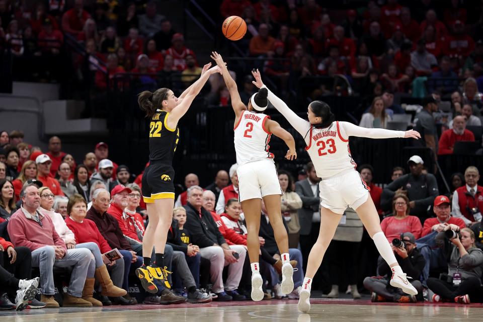 COLUMBUS, OHIO - JANUARY 21: Caitlin Clark #22 of the Iowa Hawkeyes makes a three-point shot over the defense of Taylor Thierry #2 of the Ohio State Buckeyes and Rebeka Mikulasikova #23 during the first quarter of the game at Value City Arena on January 21, 2024 in Columbus, Ohio. (Photo by Kirk Irwin/Getty Images)