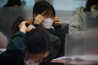 A student adjusts her mask ahead of the annual college entrance examination amid the coronavirus pandemic at an exam hall in Seoul, South Korea, Thursday, Dec. 3, 2020. South Korean officials are urging people to remain at home if possible and cancel gatherings as about half a million students prepare for a crucial national college exam. (Kim Hong-Ji/Pool Photo via AP)