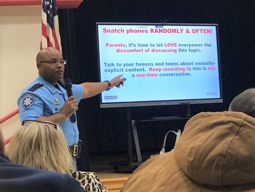Deputy Marshall Henry Tre Lewis III talks to parents and teachers gathered at Carver Elementary School about how to protect teen, tweens and younger children about the dangers both online and on social media.