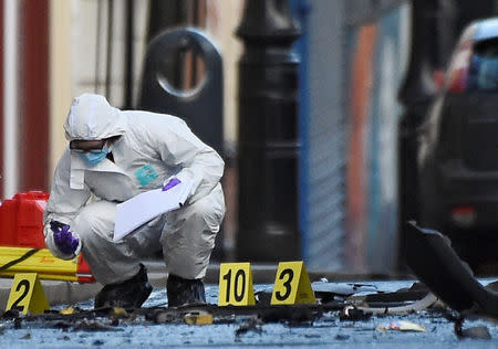 A forensic officer inspects the scene of a suspected car bomb in Londonderry, Northern Ireland January 20, 2019. REUTERS/Clodagh Kilcoyne