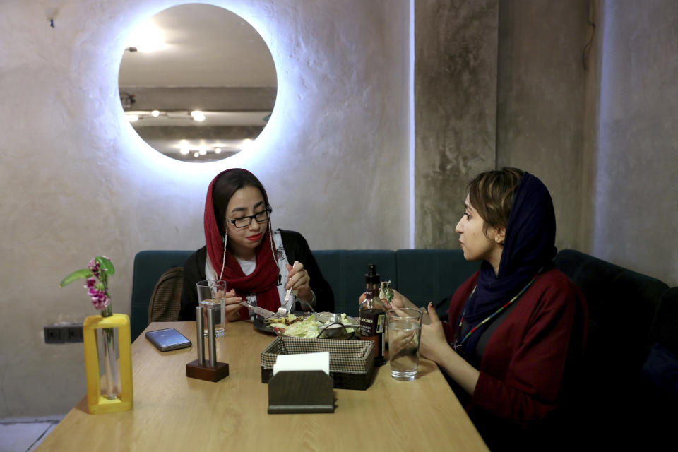 In this Monday, Oct. 7, 2019 photo, two Iranians eat at an Afghan cafe in downtown Tehran, Iran. More than 3 million Afghans including as many as 2 million who entered without legal permission, live in the Islamic Republic, according to United Nations estimates. Hamed Azar and his business partner, 21-year-old Afghan refugee Fatemeh Jafari, raised money from their parents, as well as used their own cash to open their Telma, or "Dream," Café and hope it will help bridge the divides and xenophobia Afghans can face in Iran. (AP Photo/Ebrahim Noroozi)