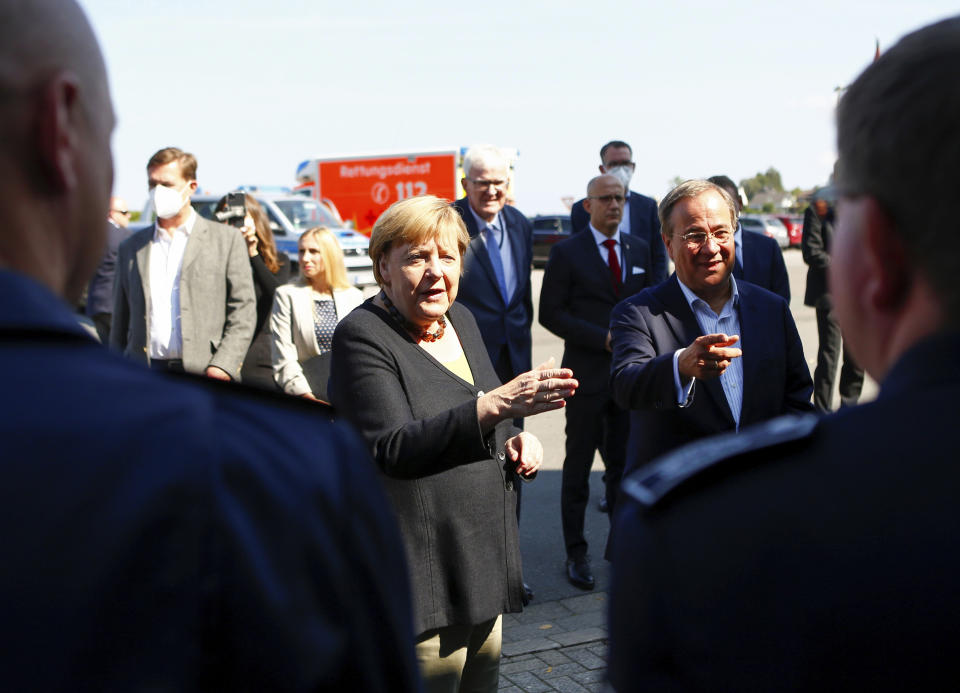 German Chancellor Angela Merkel and North Rhine-Westphalia's State Premier, chairman of the Christian Democratic Union party and candidate for Chancellery Armin Laschet, right, visit the fire station in Schalksmuehle, Germany, Sunday Sept. 5, 2021. (Thilo Schmuelgen/Pool via AP)