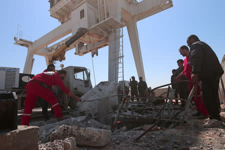 Engineers and Syrian Arab Red Crescents members inspect the damage at the northern part of the Tabqa Dam on the Euphrates river, Syria March 29, 2017. REUTERS/Rodi Said