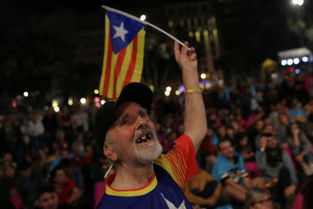 A man waves an Estelada (Catalan Sepratist flag) as people gather at Plaza Catalunya after voting ended for the banned independence referendum in Barcelona, Spain, October 1, 2017. REUTERS/Susana Vera