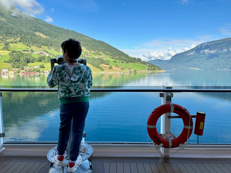 The author's son standing on cruise balcony looking out into water