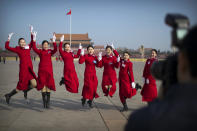 Bus ushers leap as they pose for a group photo during a meeting one day ahead of the opening session of China's National People's Congress (NPC) at the Great Hall of the People in Beijing, Monday, March 4, 2019. A year since removing any legal barrier to remaining China's leader for life, Xi Jinping appears firmly in charge, despite a slowing economy, an ongoing trade war with the U.S. and rumbles of discontent over his concentration of power. (AP Photo/Mark Schiefelbein)