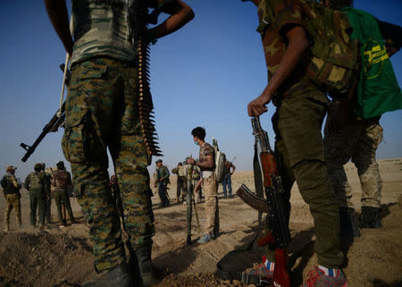 Popular Mobilization Forces (PMF) members stand with their weapons before clashes with Islamic State fighters on the outskirts of the town of Hammam Al-Alil in the south of Mosul, Iraq October 30, 2016. REUTERS/Stringer