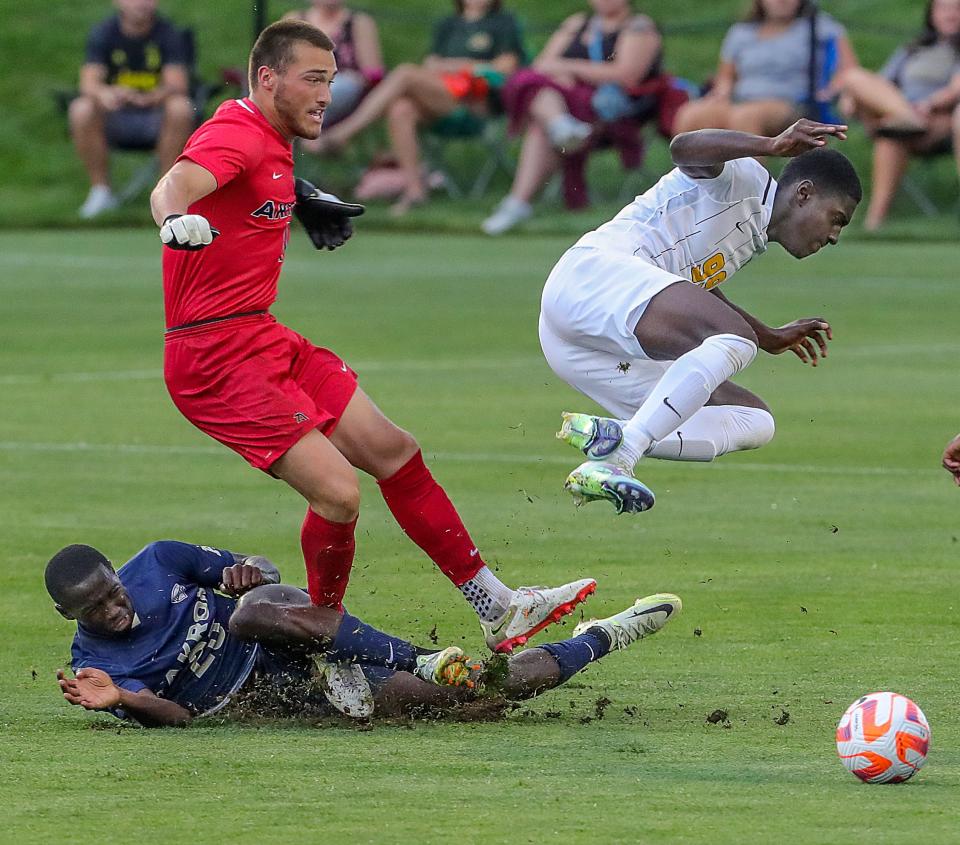 University of Akron's Joel Sangwa, left, and keeper Mitch Budler clear the ball away from VCU's Jean-Claude Bile on Monday, Aug. 29, 2022 in Akron, Ohio, at FirstEnergy Stadium.