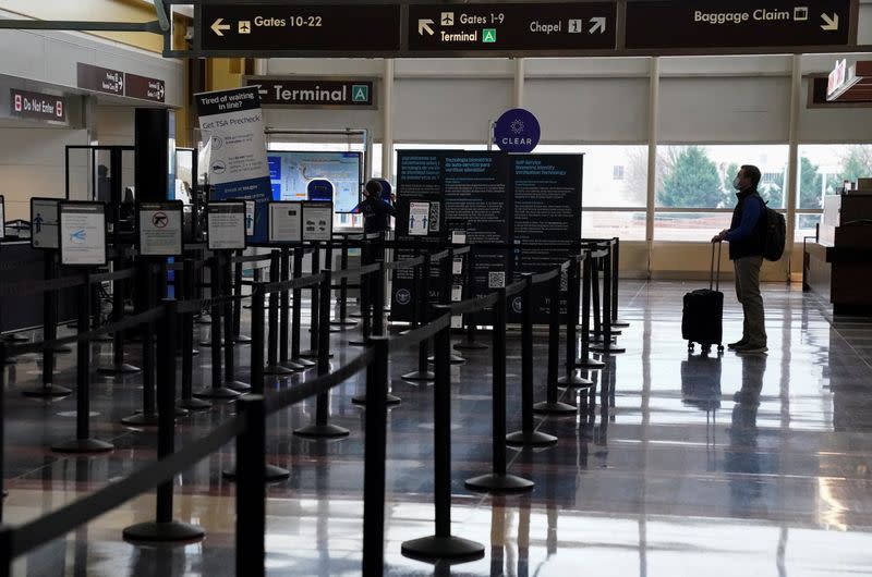 FILE PHOTO: A traveler stands by a security gate at Ronald Reagan Washington National Airport in Arlington, Virginia