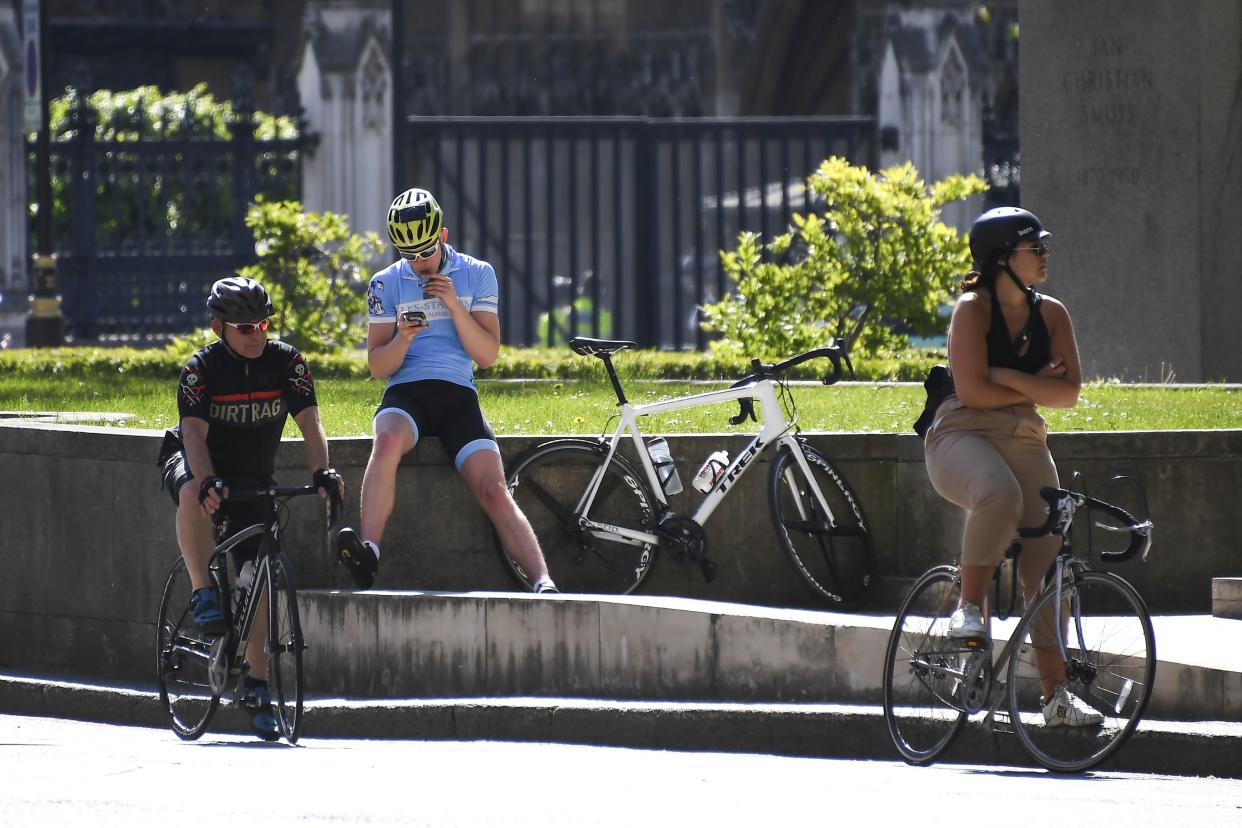 Cyclists wait at Parliament Square in London, England on Monday, May 18, 2020. Large areas of London are to be closed to cars and vans to allow people to walk and cycle safely as the coronavirus lockdown is eased.