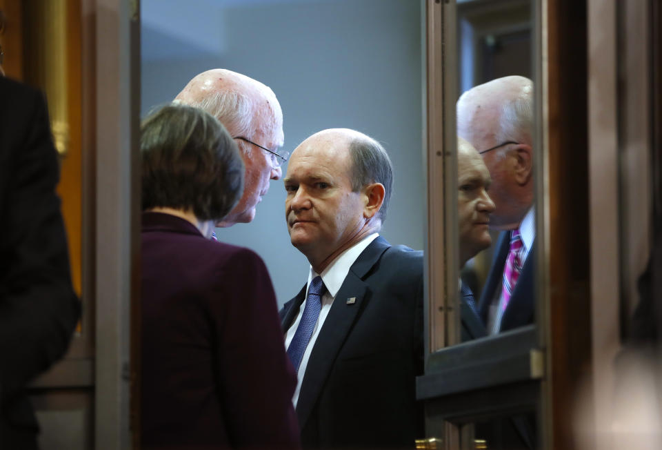 Sen. Chris Coons, D-Del., center, with Sen. Patrick Leahy, D-Vt., and Sen. Amy Klobuchar, D-Minn., left, are seen inside the anteroom during the Senate Judiciary Committee meeting, Friday, Sept. 28, 2018, on Capitol Hill in Washington. After a flurry of last-minute negotiations, the Senate Judiciary Committee advanced Brett Kavanaugh's nomination for the Supreme Court after agreeing to a late call from Sen. Jeff Flake, for a one-week investigation into sexual assault allegation against the high court nominee. (AP Photo/Pablo Martinez Monsivais)