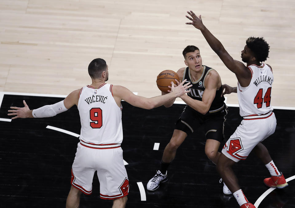 Atlanta Hawks' Bogdan Bogdanovic (13) looks to shoot against Chicago Bulls' Nikola Vucevic (9) and Patrick Williams (44) during the first half of an NBA basketball game Friday, April 9, 2021, in Atlanta. (AP Photo/Ben Margot)