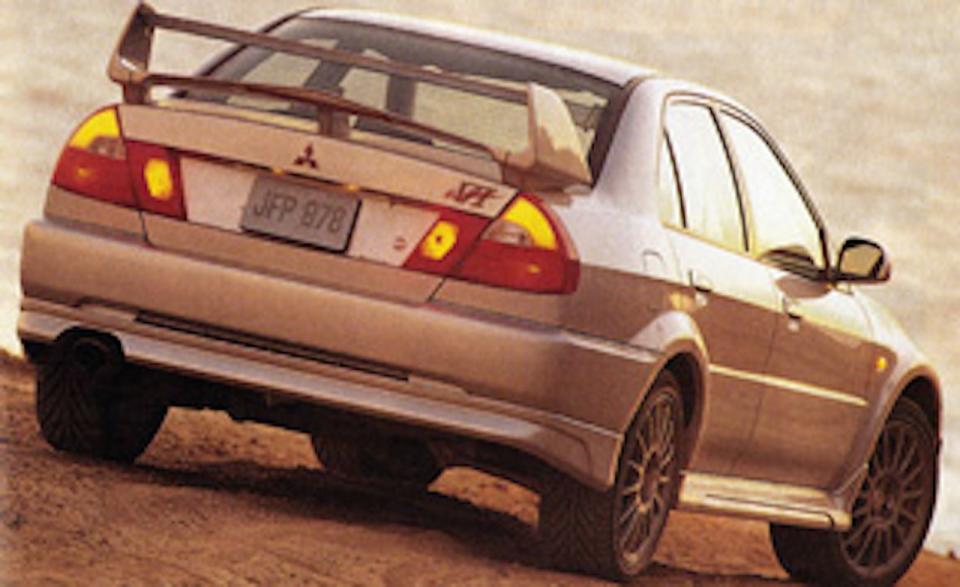 <a href="http://www.caranddriver.com/reviews/mitsubishi-lancer-evolution-vi-specialty-file" rel="nofollow noopener" target="_blank" data-ylk="slk:Car and Driver tested its first Evo;elm:context_link;itc:0;sec:content-canvas" class="link "><em>Car and Driver</em> tested its first Evo</a> in May 2000 when at least one Evo VI made it into America. Closely related to the Evo V, the VI was built to be more durable than its predecessors with better cooling, a larger intercooler, and a revised front bumper that let more air through. Under difficult testing conditions, the German-market Evo VI ripped to 60 mph in 5.1 seconds and knocked off the quarter-mile in 13.9 seconds at 102 mph. “Launching the four-wheel-drive car is a lesson in clutch abuse since you can't spin the tires with a clutch drop,” wrote <em>C/D</em>’s Barry Winfield. “To make matters worse, our testing surface was extremely grippy, making a good launch difficult. We also ran the car to its 7000-rpm redline in fifth gear, which calculates (thanks to revs-per-mile tire specs we had to telephone to Belgium for) to 148 mph.”