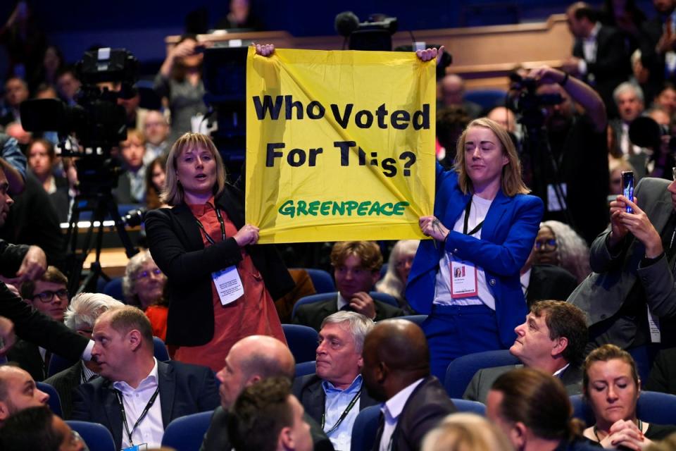 People hold up a sign in protest during British Prime Minister Liz Truss's speech, during Britain's Conservative Party's annual conference in Birmingham (REUTERS)
