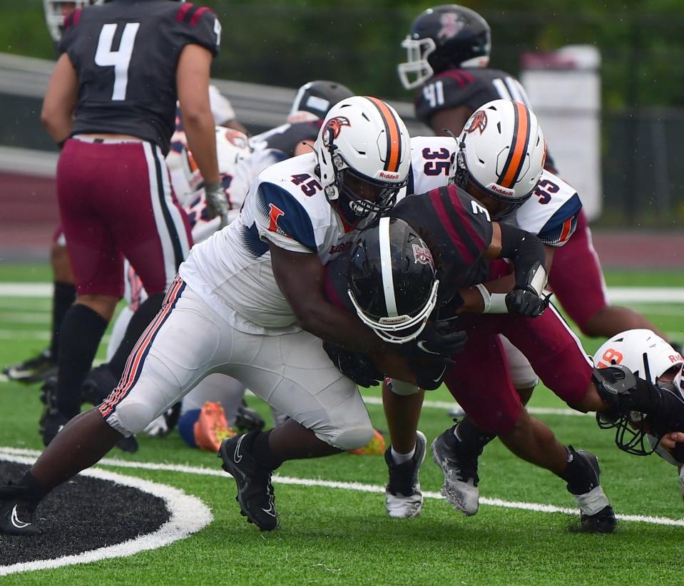 Elmira's Kayon Flint is tackled by Liverpool's Ty Kere Jones (45) and Isaiah Morris (35) during the Express football team's season opener against Liverpool on Sept, 8, 2023 at Elmira High School. The game was called early in the second quarter because of lightning.