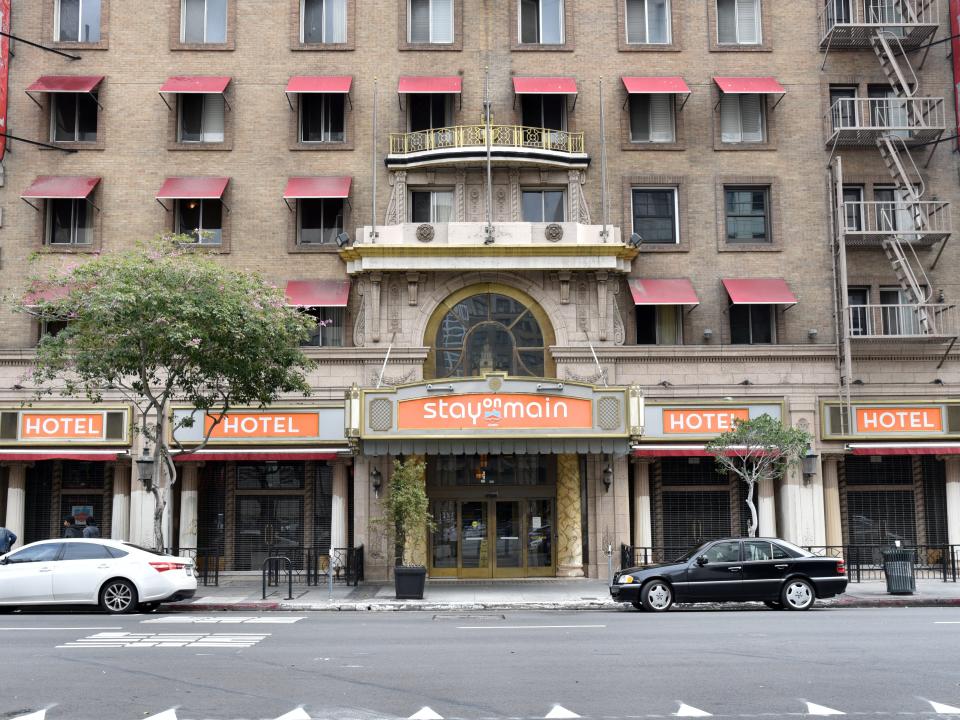 Front bottom floors and entrance of hotel with orange Stay on Main signs.