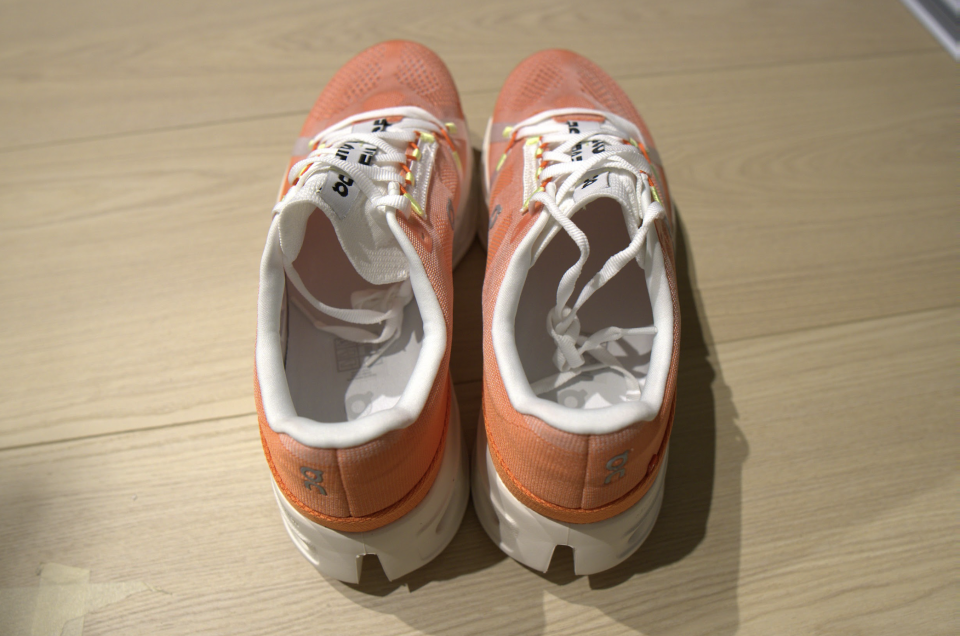 top view of orange Cloudeclipse running shoes from on on table