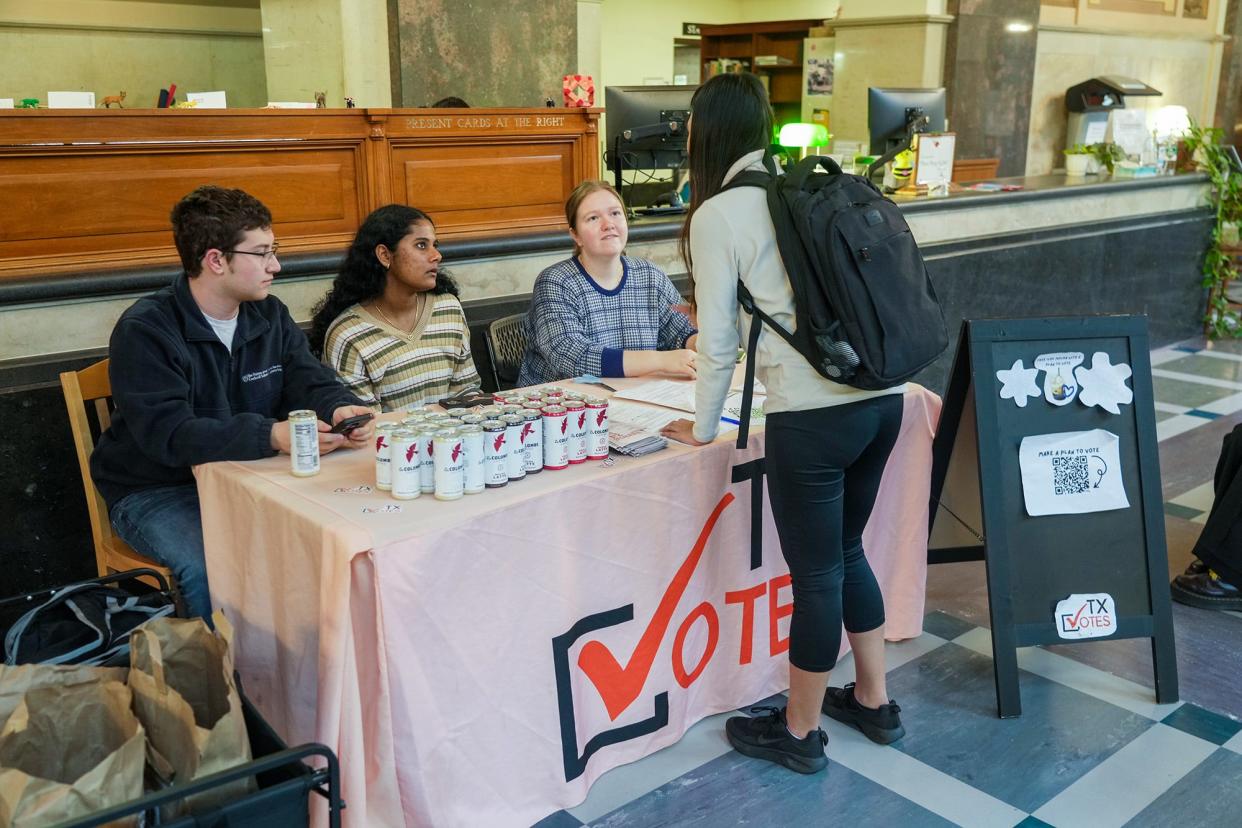 From left, Vicent Tomasetti, Akamksha Kasarabada and Sarah Batson of TX Vote help Nina Sifuentes, a senior biology major, register to vote Tuesday in the University of Texas' Main Building. Student organizations play a crucial role in promoting voter registration among their peers.