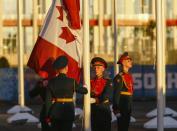 Russian soldiers raise Canada's national flag during a welcoming ceremony for the team in the Athletes Village, at the Olympic Park ahead of the 2014 Winter Olympic Games in Sochi February 5, 2014. REUTERS/Shamil Zhumatov (RUSSIA - Tags: SPORT OLYMPICS MILITARY)
