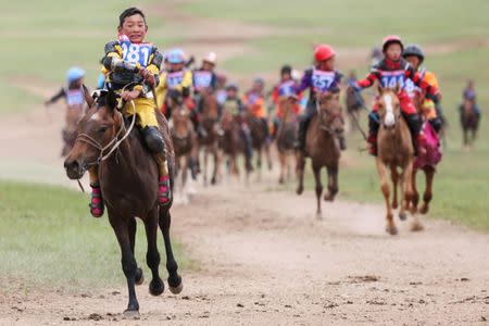 Child jockeys ride their horses to the finish line during a horse race at the Mongolian traditional Naadam festival, on the outskirts of Ulaanbaatar, Mongolia July 12, 2018. Picture taken July 12, 2018. REUTERS/B. Rentsendorj