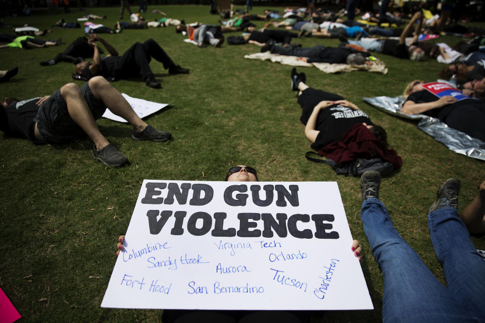 FILE - In this April 28, 2017, file photo, Nicole Alvarez holds a sign during a "die-in" protest against the National Rifle Association's annual convention where President Donald Trump is scheduled to speak a few blocks away in Atlanta. The organization has been closely aligned with Trump, who will be addressing the 2019 NRA annual meeting, the third consecutive year he’s appeared before the group. (AP Photo/David Goldman, File)