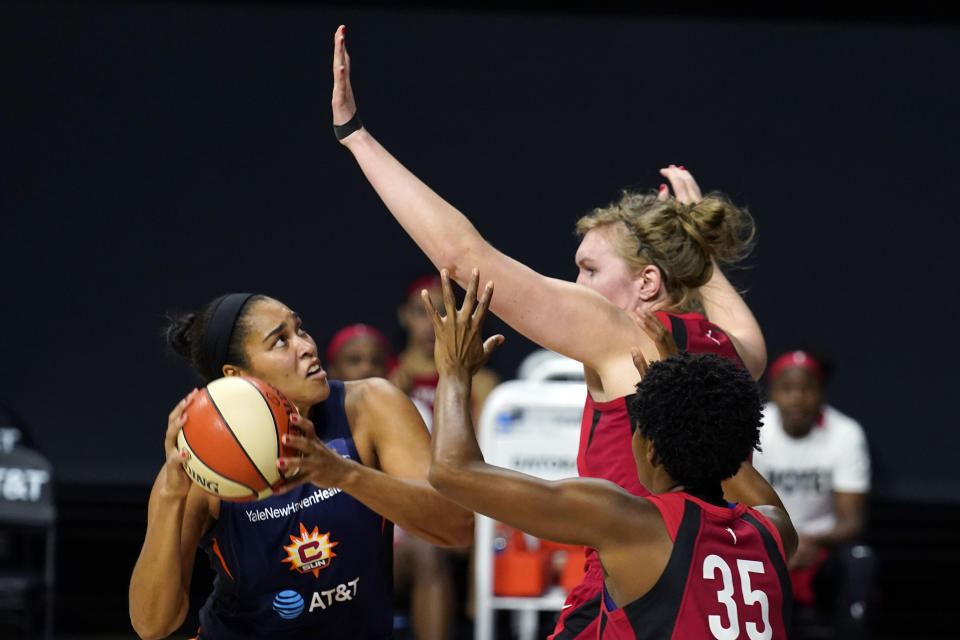 Connecticut Sun center Brionna Jones (42) goes up for a shot against Las Vegas Aces center Carolyn Swords (4) and guard Danielle Robinson (35) during the second half of Game 3 of a WNBA basketball semifinal round playoff series Thursday, Sept. 24, 2020, in Bradenton, Fla. (AP Photo/Chris O'Meara)