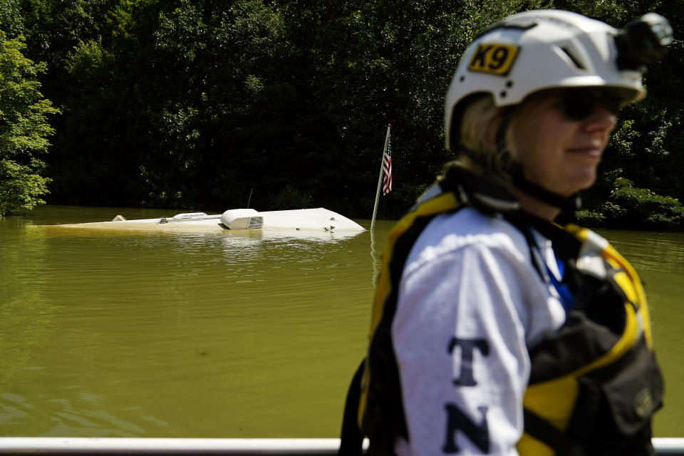 A camper with an American flag attached is seen under water as Jackie Johnson rids by in a boat in Carr Creek Lake on Wednesday, Aug. 3, 2022, near Hazard, Ky. (AP Photo/Brynn Anderson)