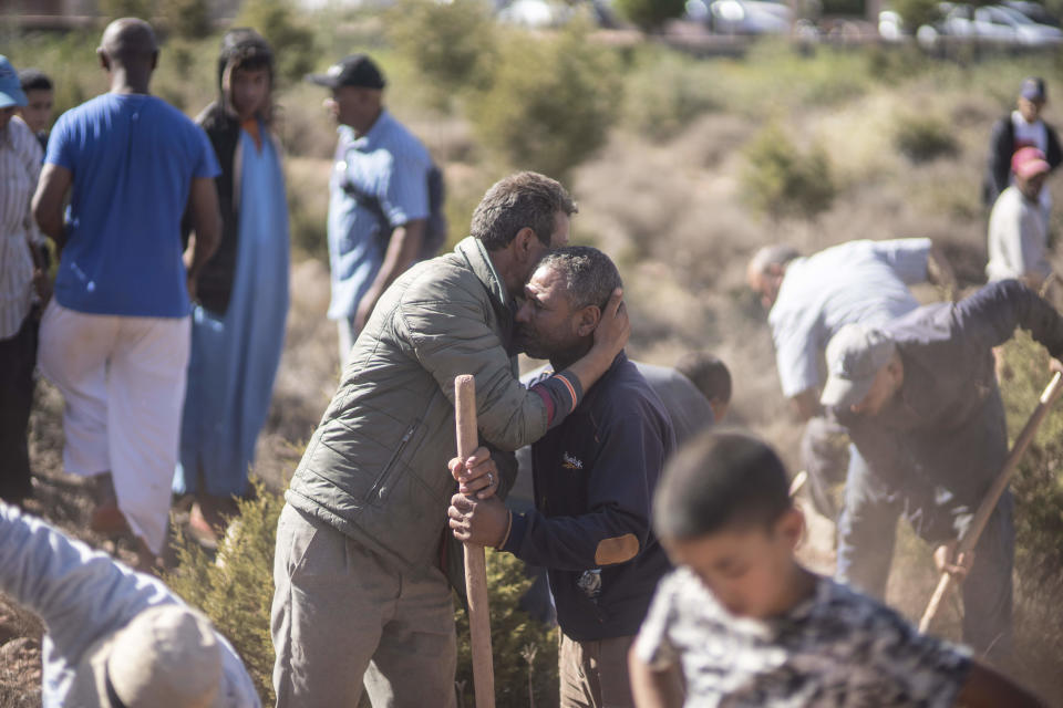 People comfort each other while digging graves for victims of the earthquake, in Ouargane village, near Marrakech, Morocco, Saturday, Sept. 9, 2023. A rare, powerful earthquake struck Morocco, sending people racing from their beds into the streets and toppling buildings in mountainous villages and ancient cities not built to withstand such force. (AP Photo/Mosa'ab Elshamy)