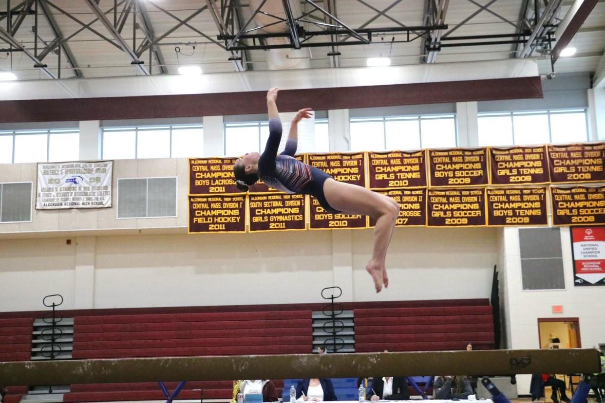 Holliston senior Emmeline Stoetzel flips on the balance beam. The apparatus became a focus for the MHM co-op program this season.