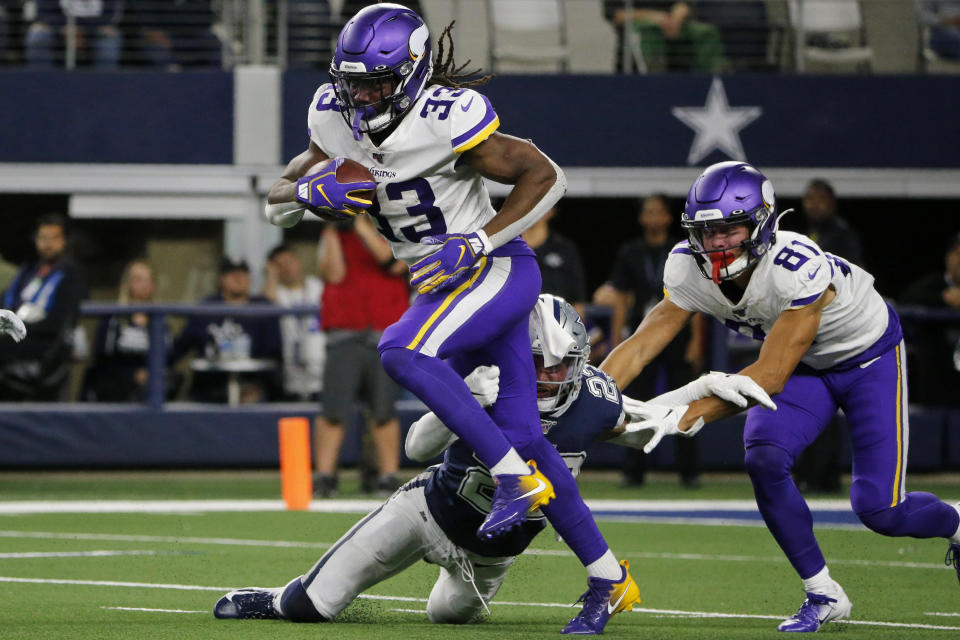 Minnesota Vikings running back Dalvin Cook (33) struggles for extra yardage as Bisi Johnson (81) helps against a tackle attempt by Dallas Cowboys' Darian Thompson (23) during the first half of an NFL football game in Arlington, Texas, Sunday, Nov. 10, 2019. (AP Photo/Michael Ainsworth)