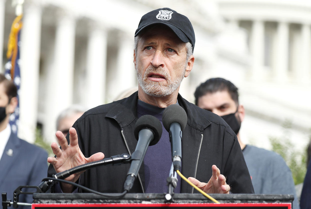 Jon Stewart stands at a podium outside the U.S. Capitol.