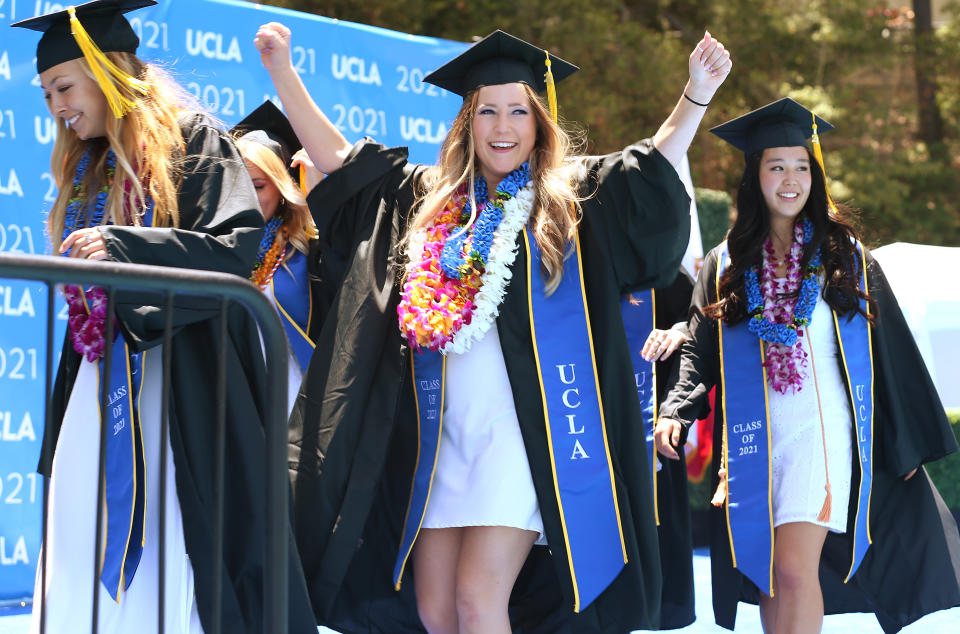 Graduating UCLA students celebrate while walking the stage for their commencement ceremony at Drake Stadium on June 11, 2021 in Westwood, California. (Photo by Mario Tama/Getty Images)