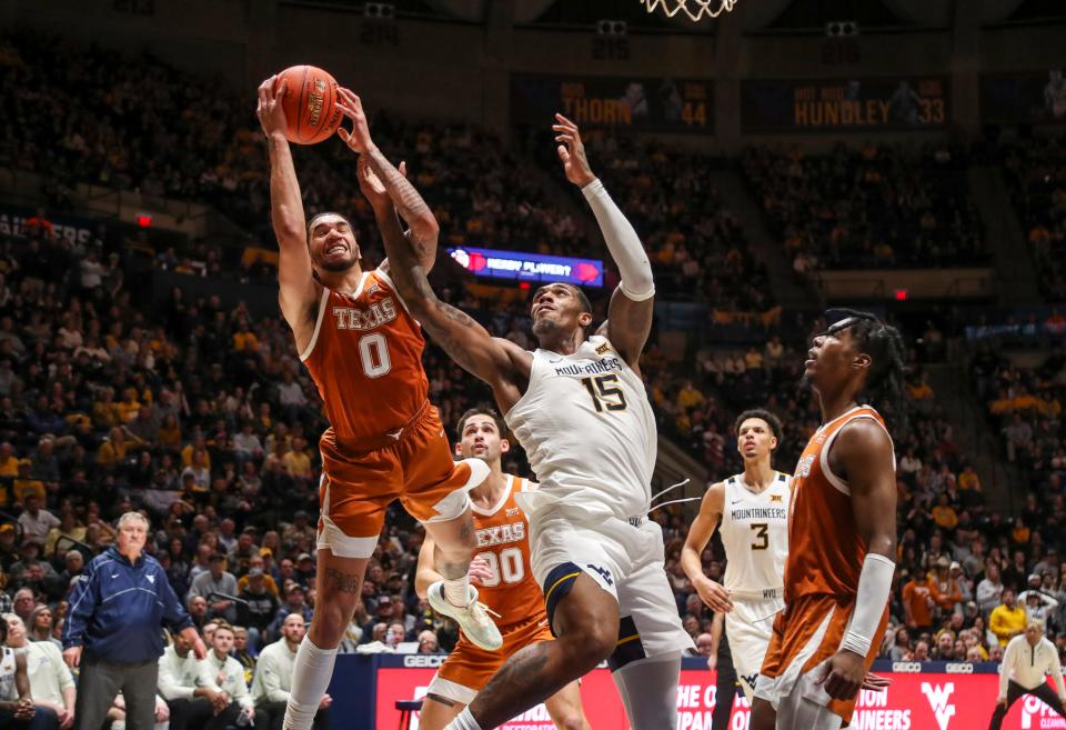 Texas forward Timmy Allen grabs a rebound over West Virginia forward Jimmy Bell Jr. during the second half Saturday night. The win improved the Longhorns to 5-2 in the Big 12 race.