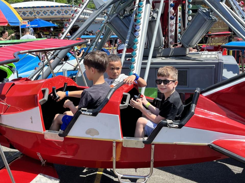 a group of boys riding in a small amusement park ride