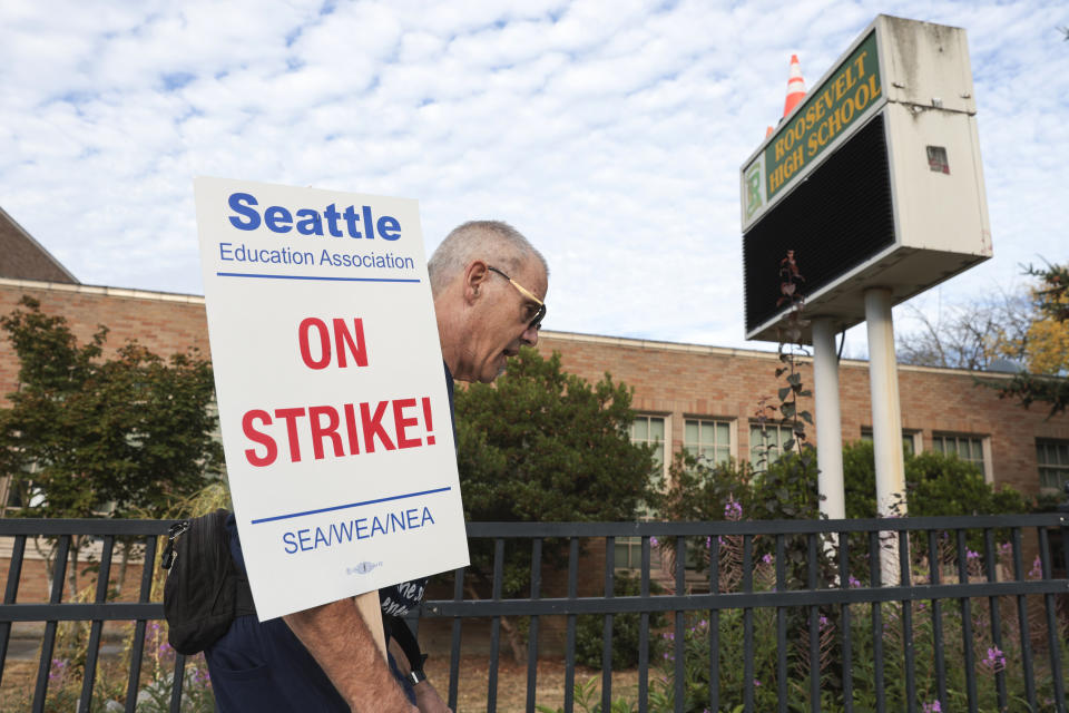 Math teacher Royce Christensen pickets outside Roosevelt High School on what was supposed to be the first day of classes as teachers from Seattle Public Schools go on strike, Wednesday, Sept. 7, 2022, in Seattle. The first day of classes at Seattle Public Schools was cancelled and teachers are on strike over issues that include pay, mental health support, and staffing ratios for special education and multilingual students. (AP Photo/Jason Redmond)