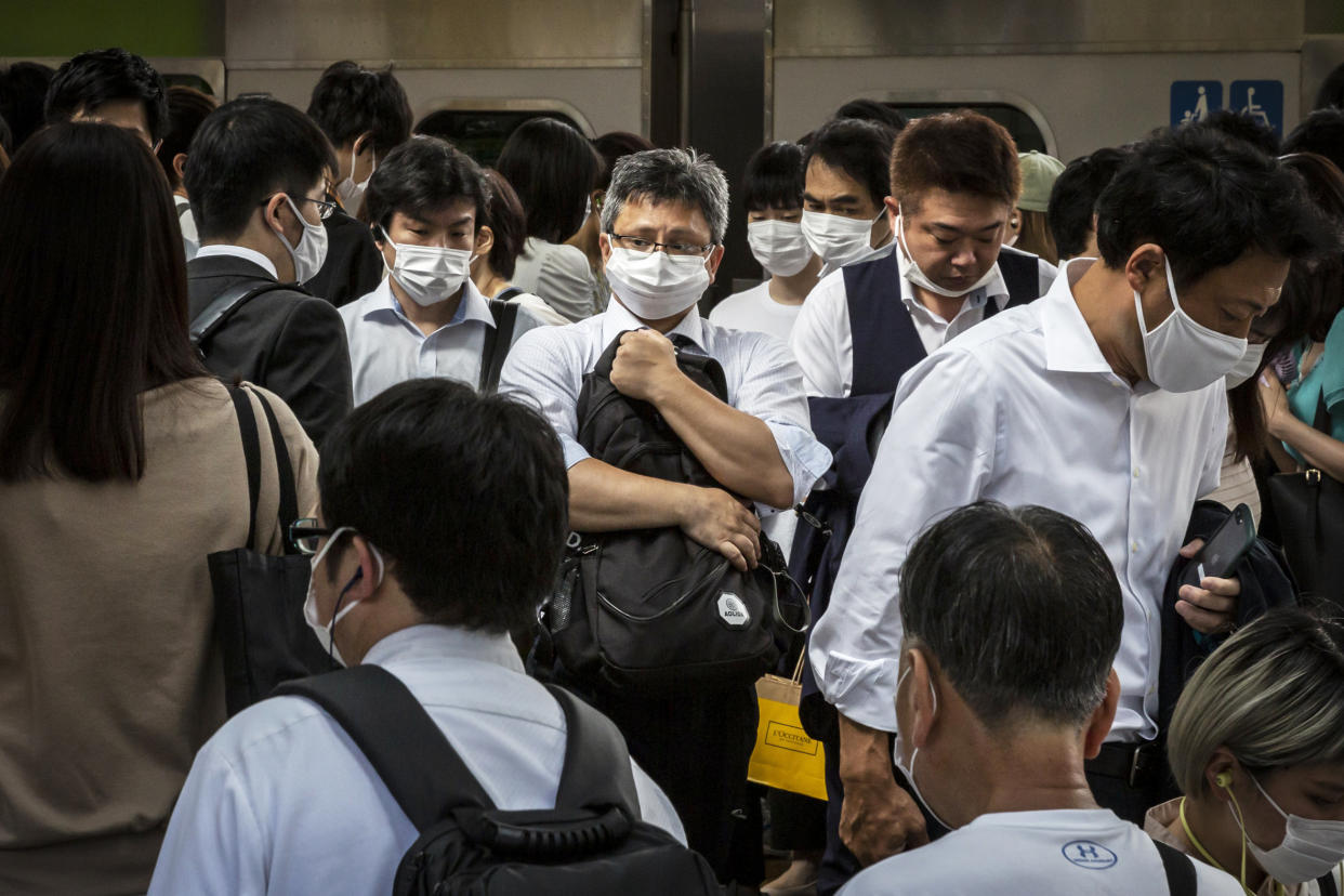 Image: Commuters disembark from a train as they travel to work on Monday. (Yuichi Yamazaki / Getty Images)