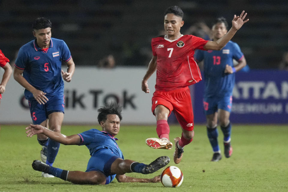 Thailand's Yotsakon Burapha, left, battles for the ball against Indonesia's Marselino Ferdinan during their men's final soccer match at the 32nd Southeast Asian Games in Phnom Penh, Cambodia, Tuesday, May 16, 2023. (AP Photo/Tatan Syuflana)