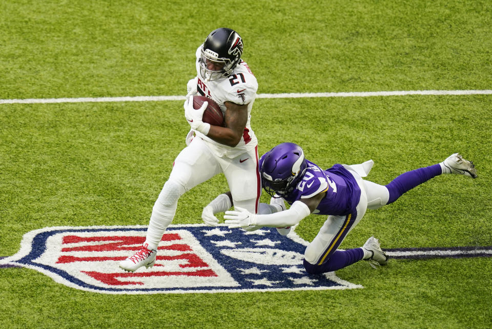 Atlanta Falcons running back Todd Gurley II (21) runs from Minnesota Vikings cornerback Jeff Gladney (20) during the first half of an NFL football game, Sunday, Oct. 18, 2020, in Minneapolis. (AP Photo/Charlie Neibergall)