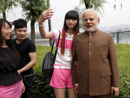 A woman poses for a selfie with a silica gel sculpture of Indian Prime Minister Narendra Modi, which was made by local sculpture artists, at a park in Xian, Shaanxi province, China, May 14, 2015. REUTERS/Stringer