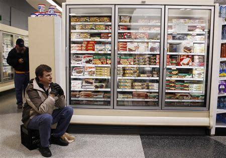 Paul Stallings sits next to the frozen section inside a Publix grocery store after being stranded due to a snow storm in Atlanta, Georgia, January 29, 2014. REUTERS/Tami Chappell