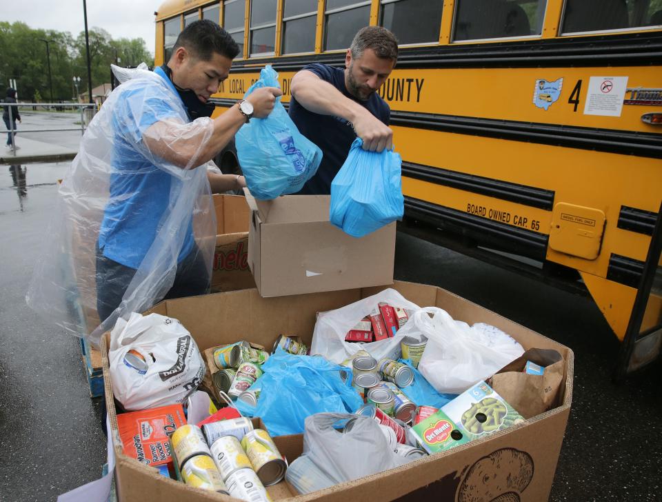 Nicholas Jones, left, and Steve Smolinski, volunteers from Surgere, work to unload a bus of food donations from a Dalton Local bus at the Akron-Canton Regional Foodbank's Stark County Campus in Canton.