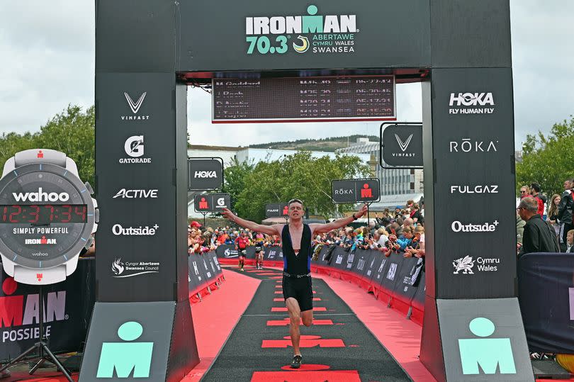 An Ironman finisher crossing the line