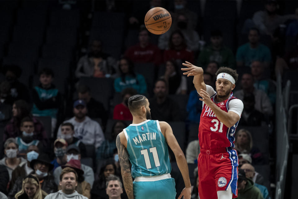 Philadelphia 76ers guard Seth Curry (31) passes the ball over Charlotte Hornets forward Cody Martin (11) during the first half of an NBA basketball game, Wednesday, Dec. 8, 2021, in Charlotte, N.C. (AP Photo/Matt Kelley)