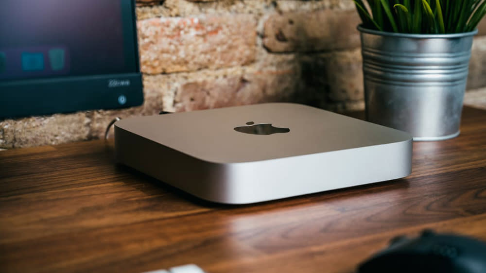  A Mac mini on a desk next to what could be one of the best monitors for Mac mini 