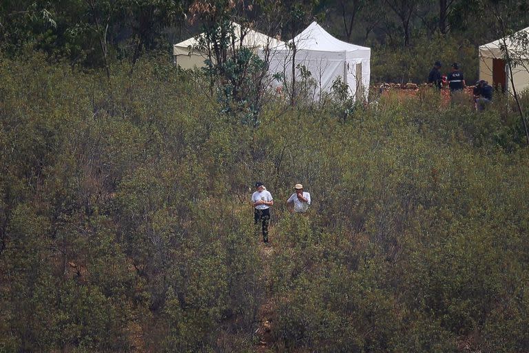 Miembros de la Policía Judicial portuguesa (PJ) trabajan cerca de tiendas de campaña en la zona del embalse Barragem do Arade, en Silves, el 24 de mayo de 2023, en el segundo día de una nueva operación de búsqueda en el marco de la investigación sobre la desaparición de Madeleine McCann.