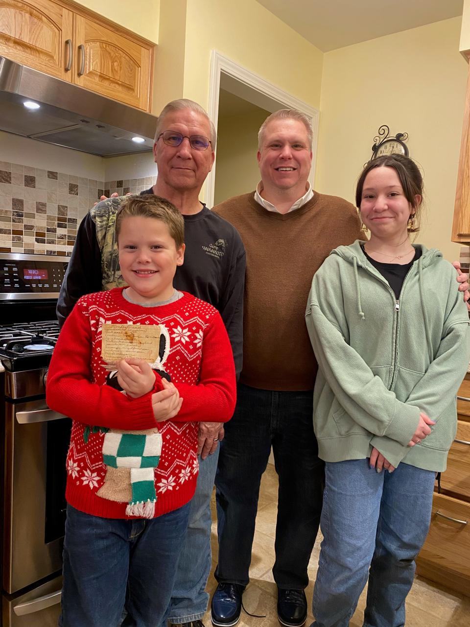David Uhl, his father Larry Uhl, his daughter Samantha Uhl, and his son Ethan Uhl with Aunt Esther's monkey bread recipe.