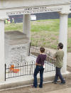 Visitors look at the burial place of President James K. Polk and his wife, Sarah Polk, on the grounds of the state Capitol in Nashville, Tenn., on Friday, March 24, 2017. A resolution being considered in the state Legislature calls for exhuming their bodies and moving them to the James K. Polk Home and Museum in Columbia, Tenn. (AP Photo/Erik Schelzig)