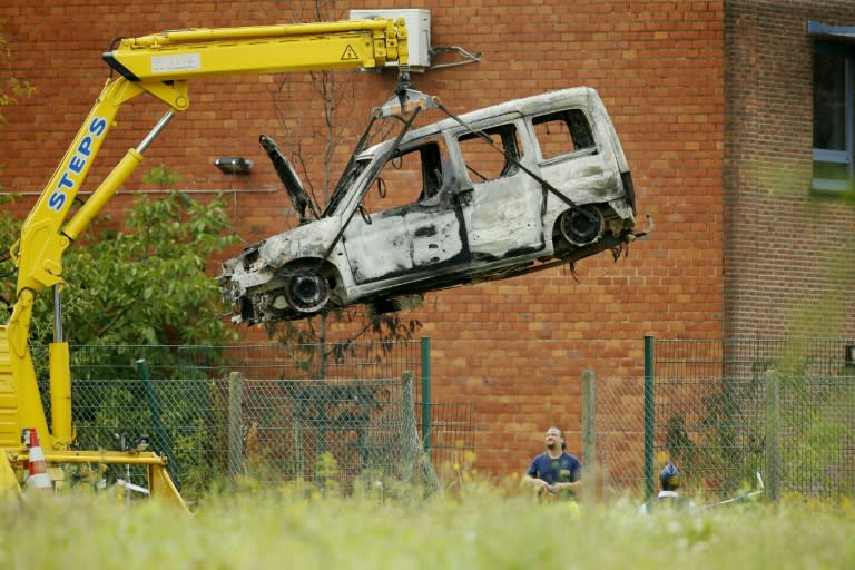 The car used to ram into the gates of Belgium's national crime laboratory, causing a fire and major damage but no casualties, is lifted up on August 29, 2016