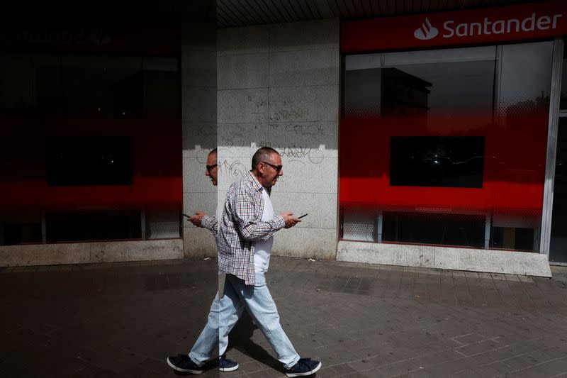 A man walks past a Santander bank branch in Madrid